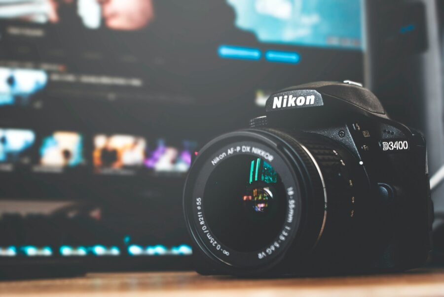 black and white Nikon D3400 DSLR camera on brown surface